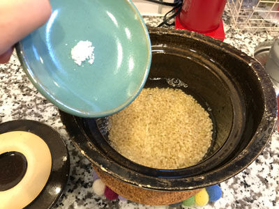 塩をひとつまみ土鍋の玄米へ。